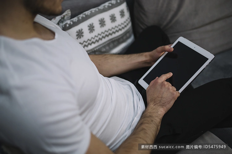 裁剪工在沙发上使用平板电脑